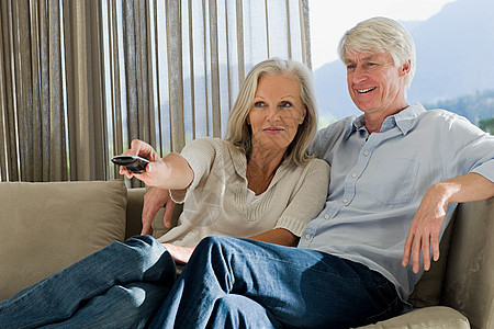 一对中年夫妇坐在沙发上看电视图片