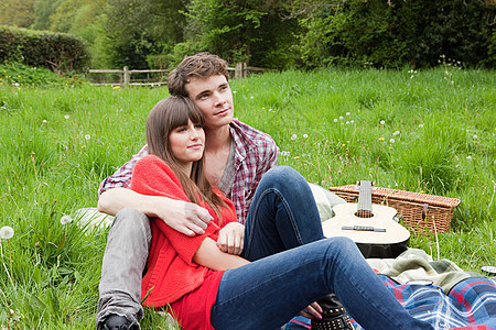 年轻夫妇在田里躺在毯子上图片