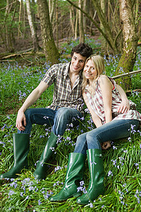 坐在风铃草中间的年轻夫妇图片