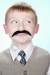 一个戴假胡子的男孩的肖像图片