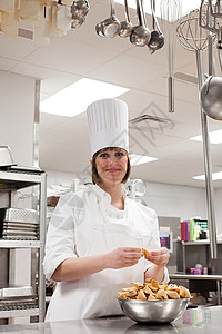 在商业厨房工作的女厨师背景图片