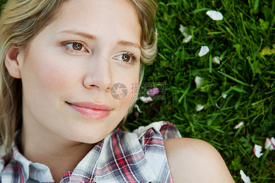 躺在草地上的年轻女子的脸图片