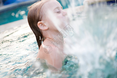 小女孩在游泳池里溅水背景图片