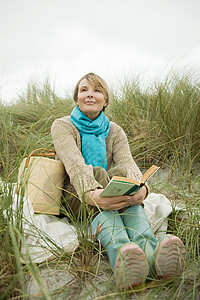 女人在海边拿着一本书图片