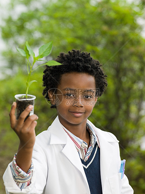 把植物放在容量瓶中的男孩图片