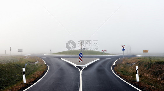 环形交叉路口和有雾中标志的道路图片