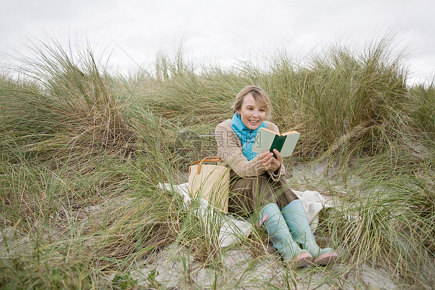 在沙丘上看书的女人