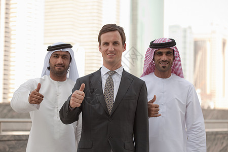 中东和西方商人竖起大拇指背景图片