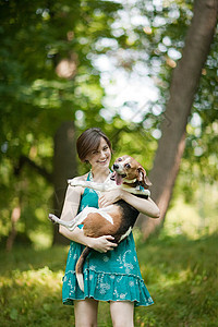 抱着宠物小猎犬的女人图片