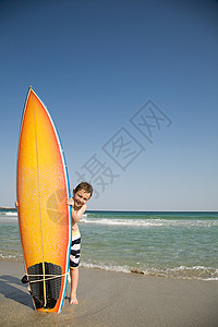 拿冲浪板男孩男孩把冲浪板放在沙子里背景