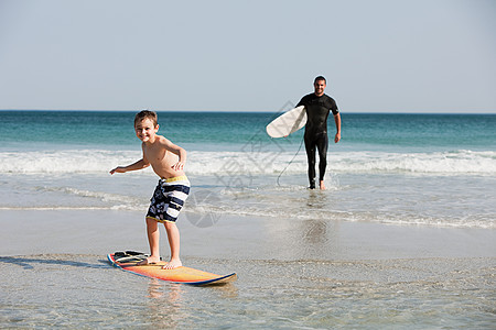 玩冲浪的孩子小男孩在浅水中冲浪背景