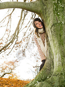 站在树后微笑的女人图片