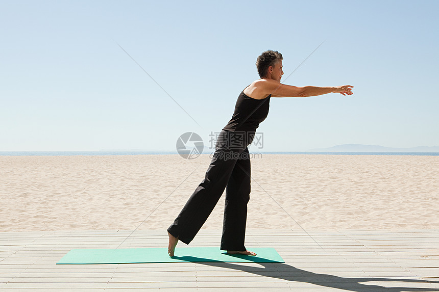 在海滩上做瑜伽的女士图片