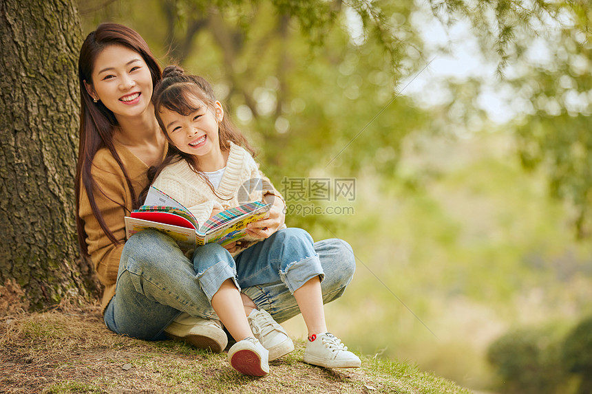 温馨母女坐在树下读书 图片