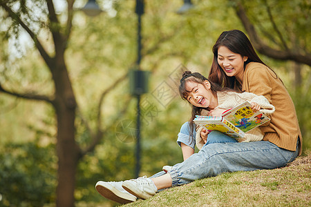 户外休闲温馨母女坐在树下读书背景