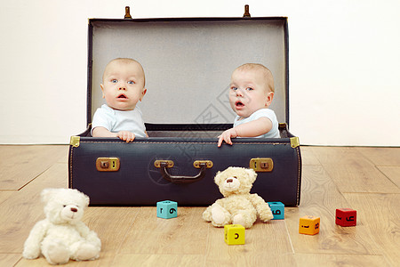 两个男婴坐在手提箱里图片