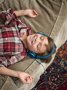 男孩在沙发上戴着耳机图片