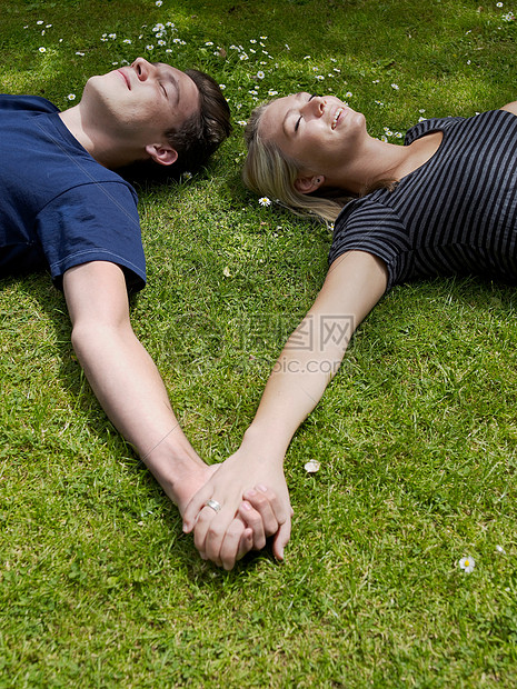 一对夫妇手牵手在草地上图片