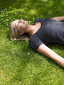 微笑的女人躺在草地上图片