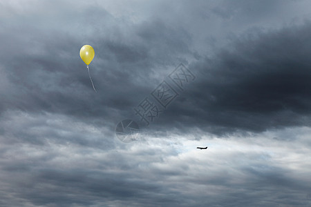 黄色气球飘向多云的天空图片