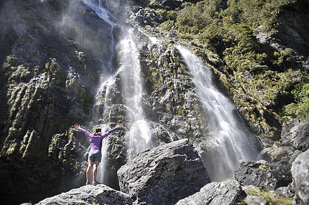 新西兰站在瀑布边伸出双臂的女人图片