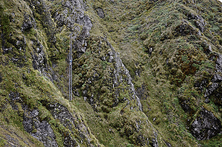 新西兰山脊女登山者登高的远视图图片