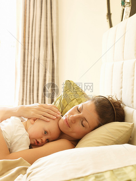母亲抱着婴儿在床上图片