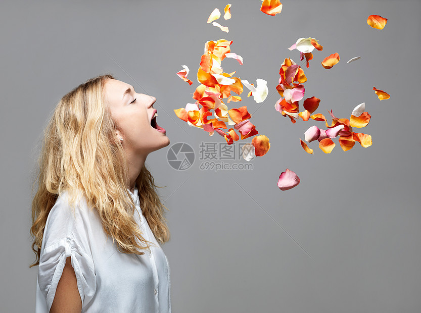 少妇张开嘴吃飘浮在半空中的花瓣图片