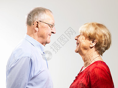 老年夫妇面对面站在白色背景下背景图片