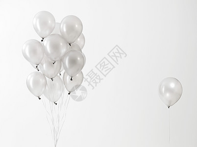 白色背景下漂浮的银色气球图片