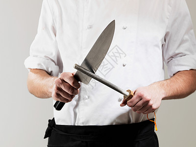 厨师在白色背景下磨刀图片