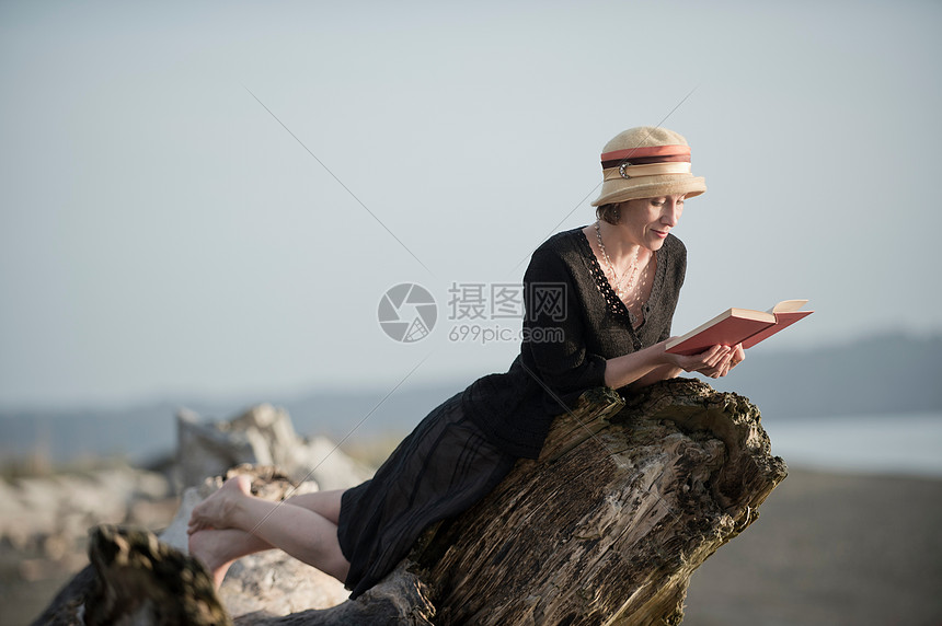 躺在浮木上看书的女人图片