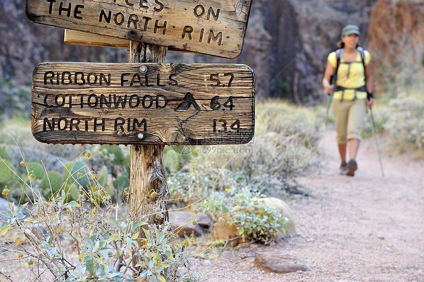 美国亚利桑那州弗拉格斯塔夫大峡谷女性徒步旅行者和乡村标志图片