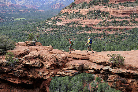 美国亚利桑那州塞多纳拱形岩层上的登山夫妇图片