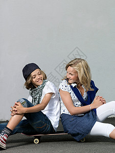 两个孩子坐在滑板上背景图片
