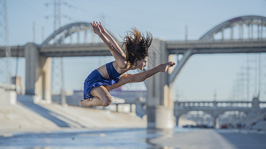 美国加利福尼亚州洛杉矶大桥前空中跳起的舞者侧视图图片