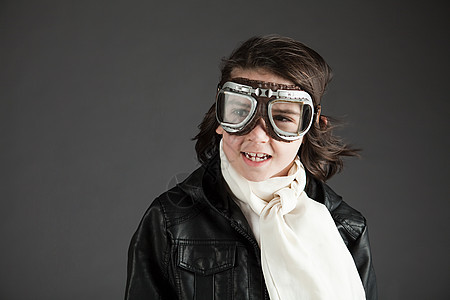 年轻的男孩戴着飞行护目镜打扮成飞行员图片