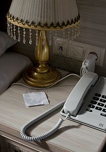 酒店客房床头柜上的固定电话和空白纸条图片
