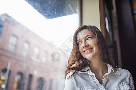 黑发微笑低角度的年轻女子肖像图片