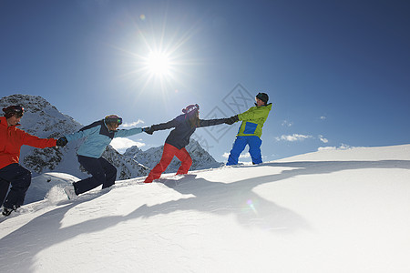 奥地利库赫泰朋友们在雪地里互相拉着上坡背景图片