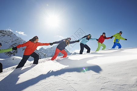 奥地利库赫泰朋友们在雪地里互相拉着上坡背景图片