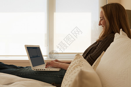 在家工作的女性使用笔记本电脑背景图片
