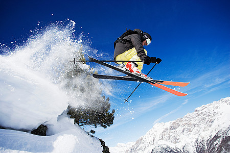 一个男子滑雪运动员在山上半空背景