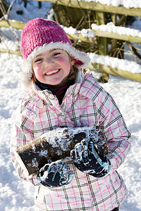 在雪地里扛木头的小女孩图片