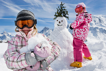 雪人在滑雪堆雪人的女孩背景