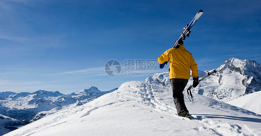 走过山脊的滑雪者图片