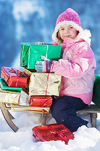 在雪橇上拿礼物的女孩图片