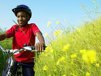 在花丛里骑自行车的男孩图片