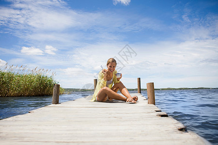 坐在湖边吃酸奶的女人图片