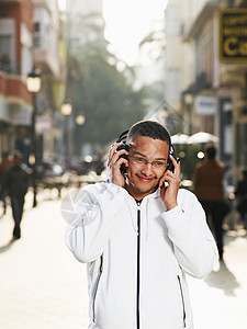 戴着耳机的年轻人在街上图片